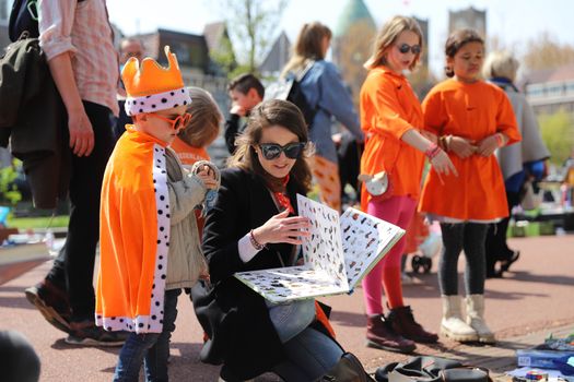 Drukke oranje menigte tijdens een Koningsdag festival in Groningen met podia, terrassen en feestelijke binnenstadssfeer